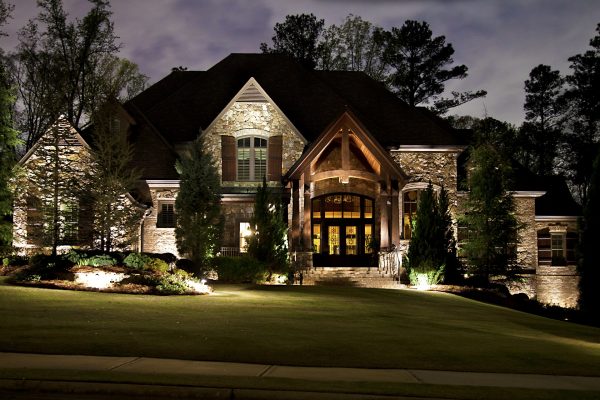 Outdoor lighting illuminating Charlotte home at dusk