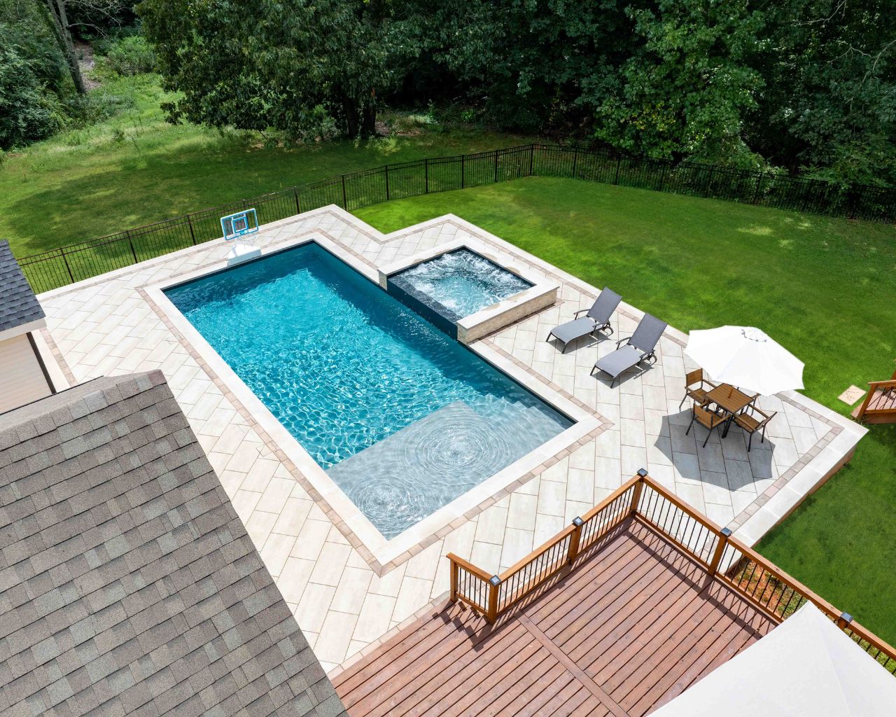 a custom swimming pool with a beautiful patio surrounding it